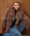 A woman wears a luxurious brown Mongolian fur coat with long sleeves and a voluminous silhouette, exuding warmth and high-fashion elegance.